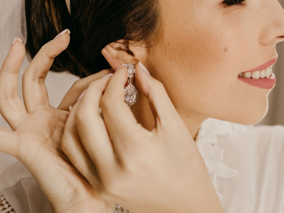 A bride is wearring a teardrop diamond earrings.