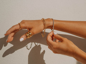Women wear gold bracelets and gold rings.