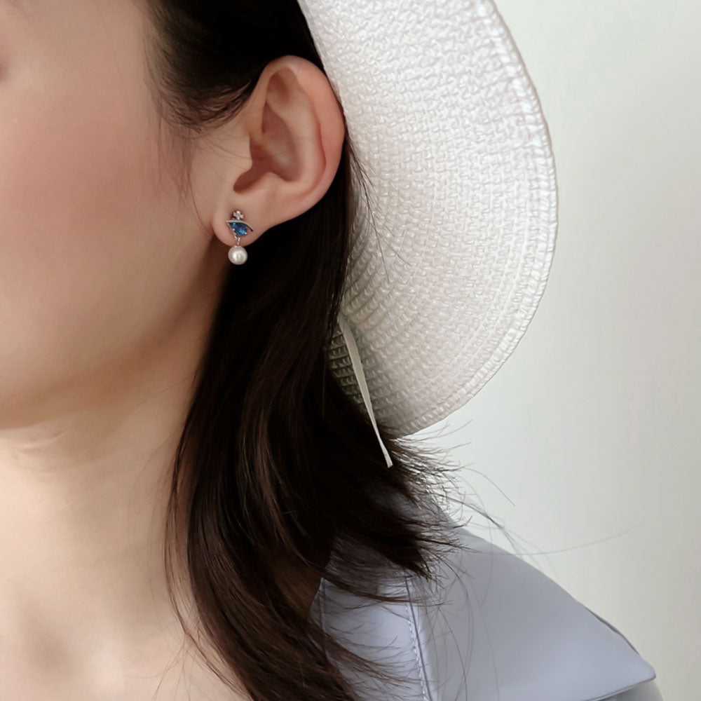 Women wear blue pearl earrings.
