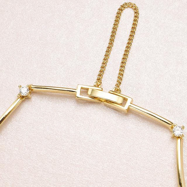 A closed gold chain bracelet clasp.
