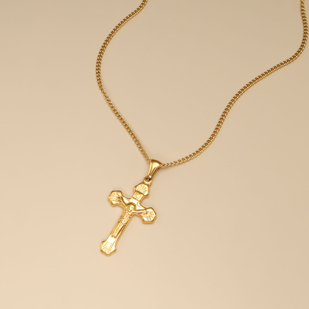 A gold corss necklace.