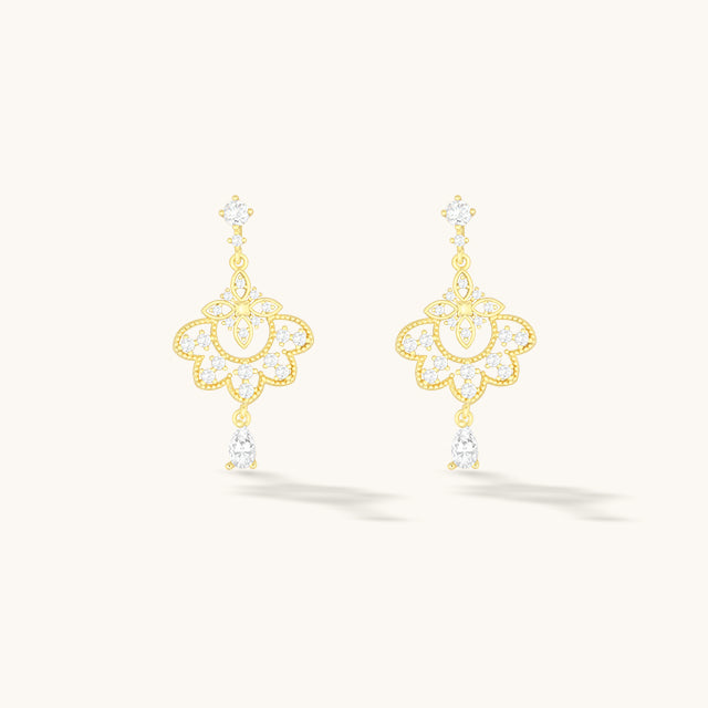 A pair of gold dangle earrings.