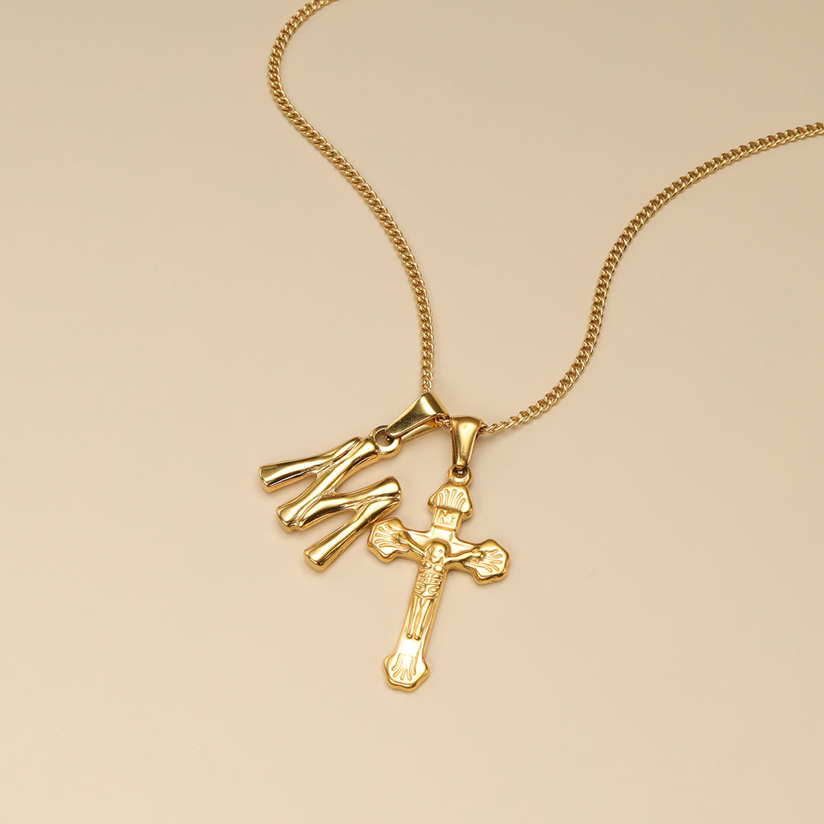 Gold letter pendants with M and cross.