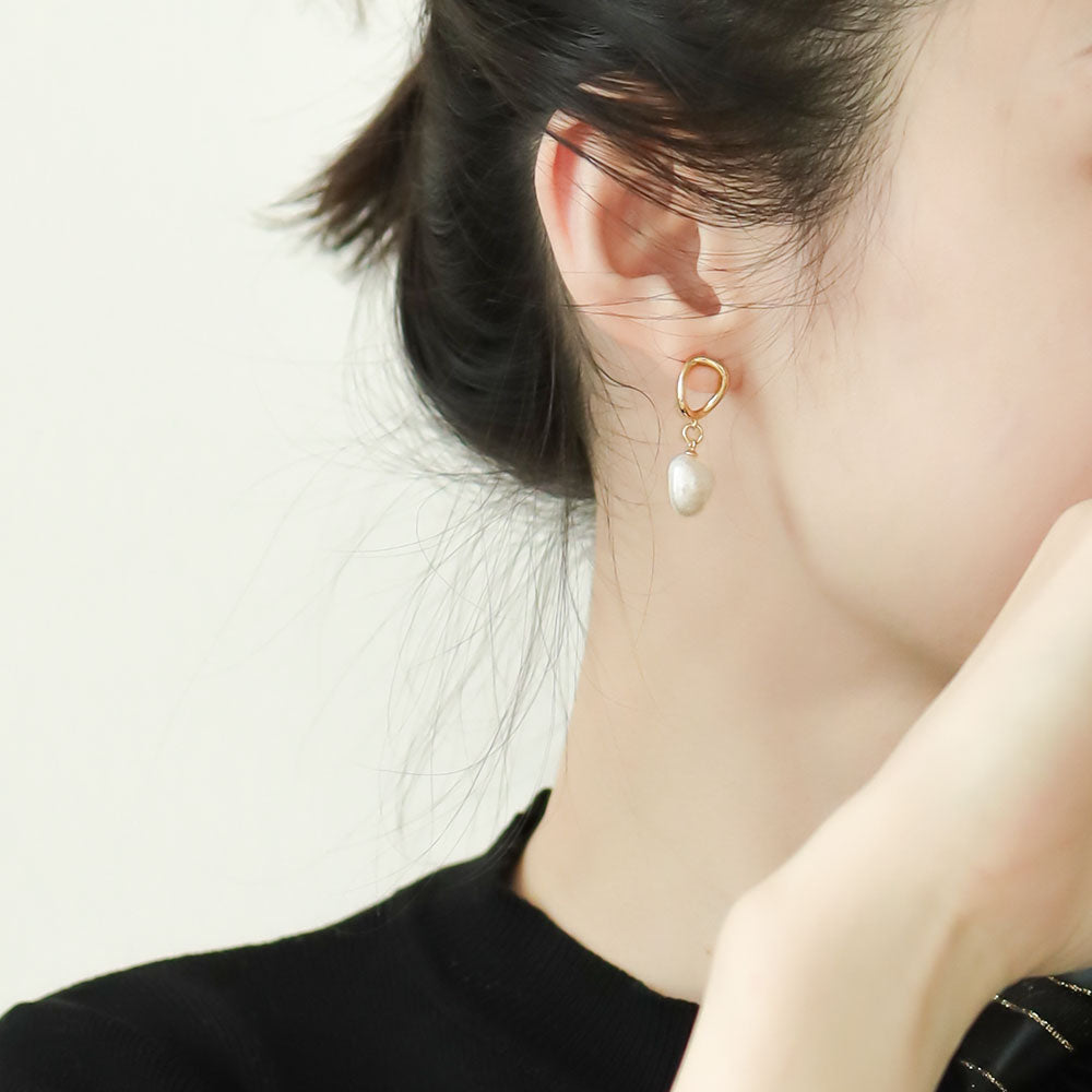 Women wears pearl dangle earrings,