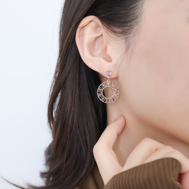 Purple zirconia earrings on women ear.