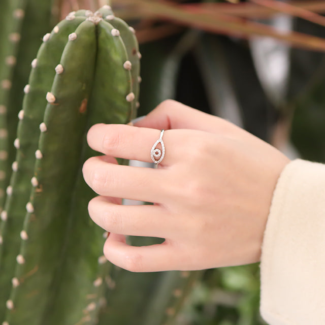 A hand on cactus with silver eye ring.
