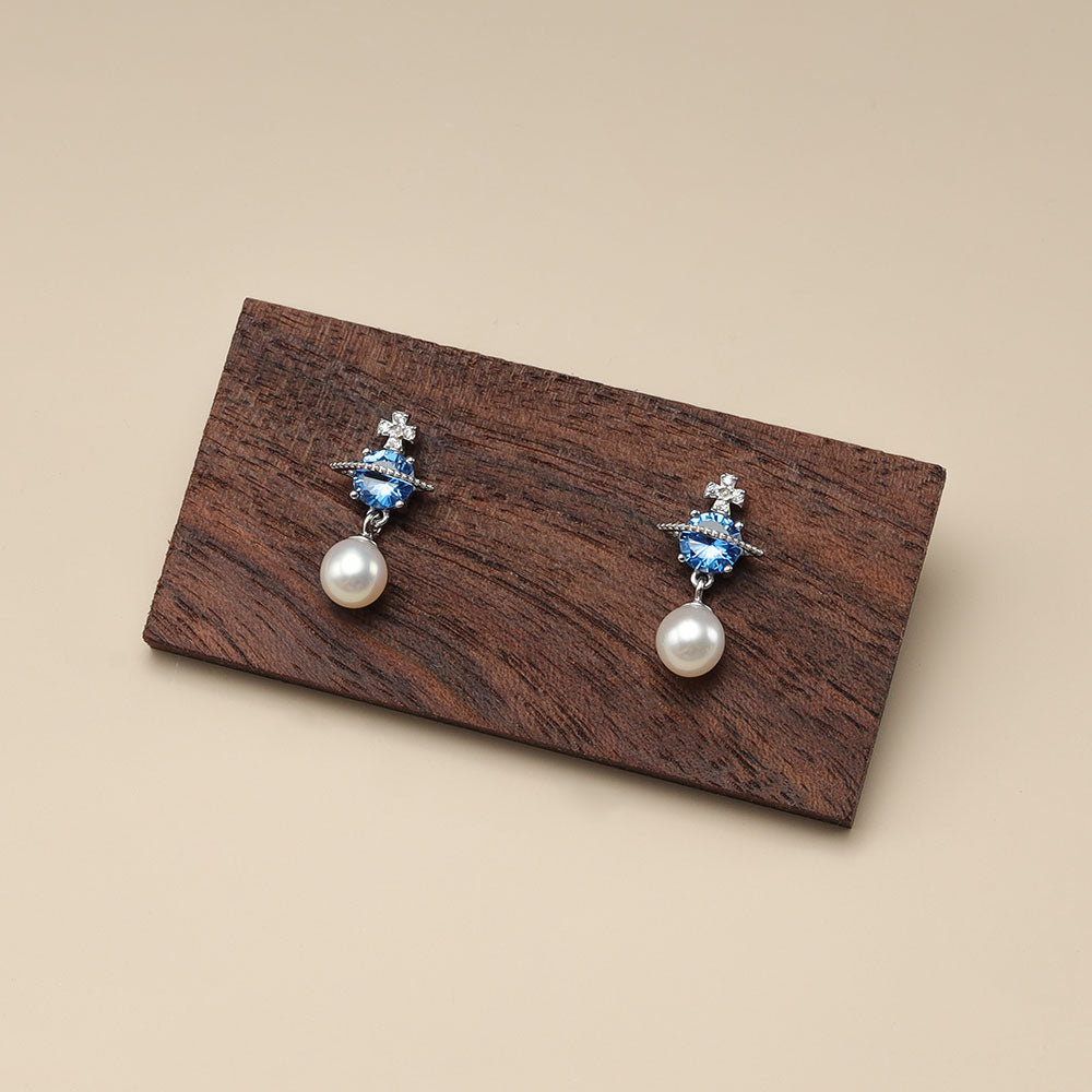 Saturn pearl earrings.