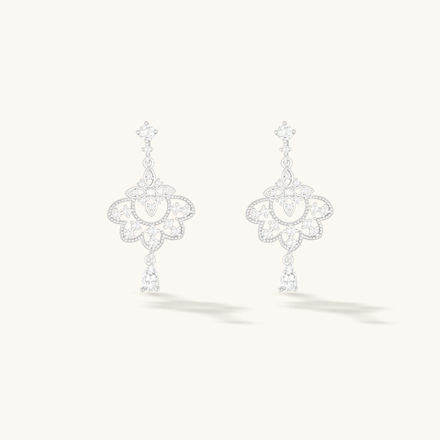 A pair of silver dangle earrings.