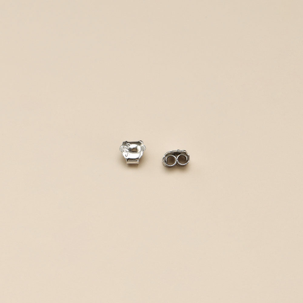 A pair of silver earrings backs.