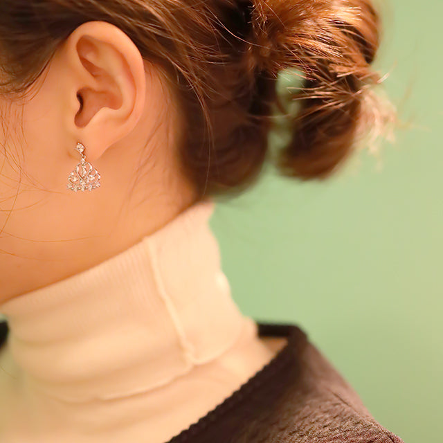 Silver earrings on women ear.