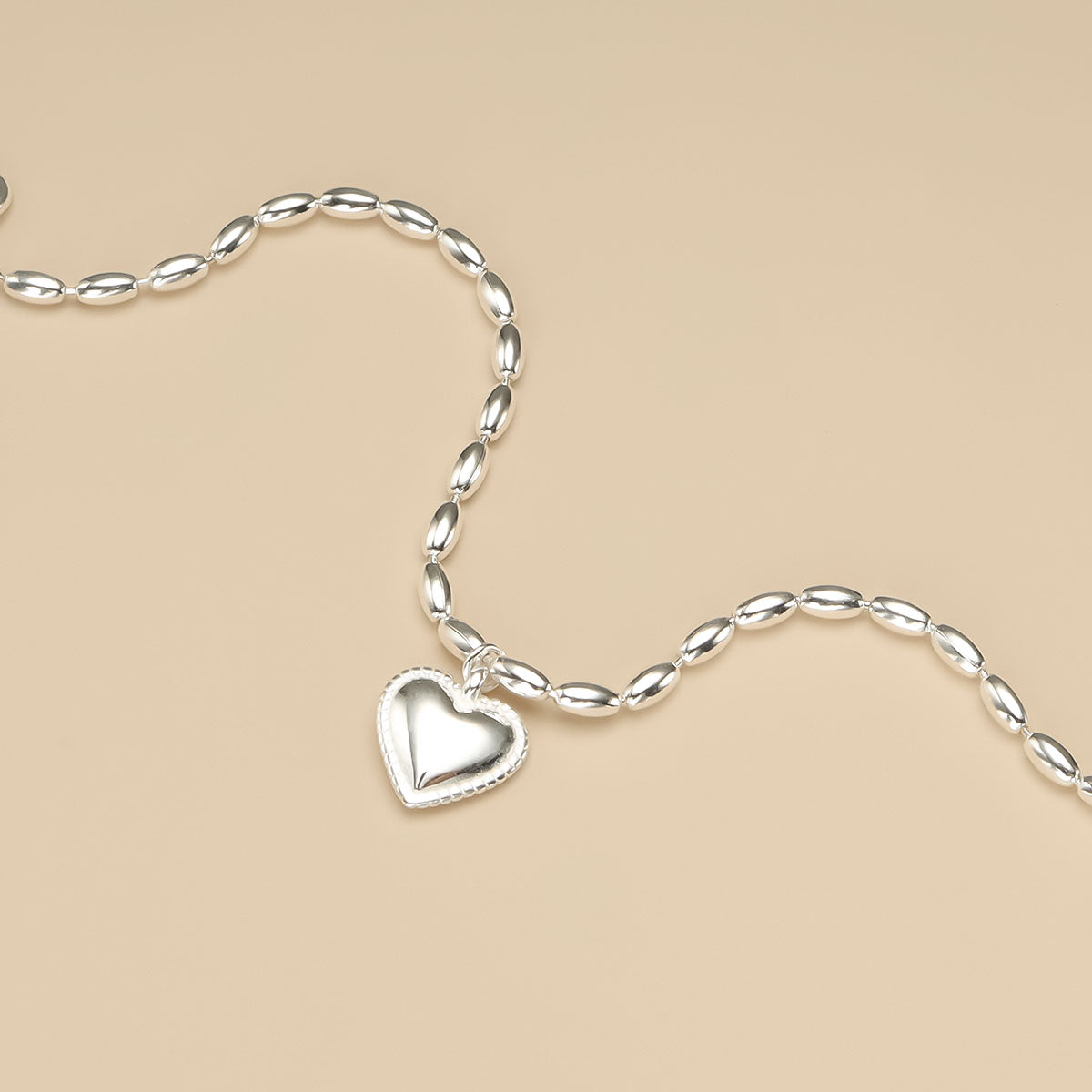 The close shot of silver heart bracelet.
