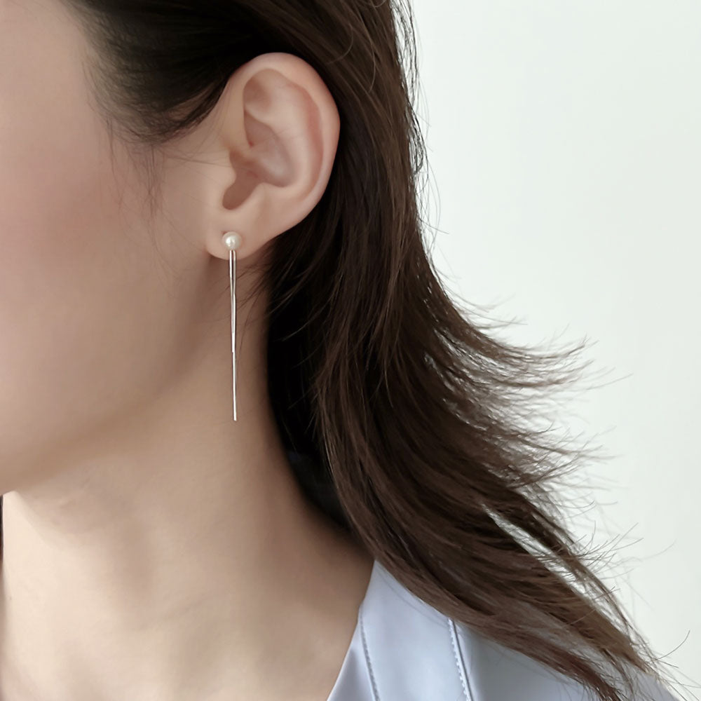 Women wear silver tassel earrings.