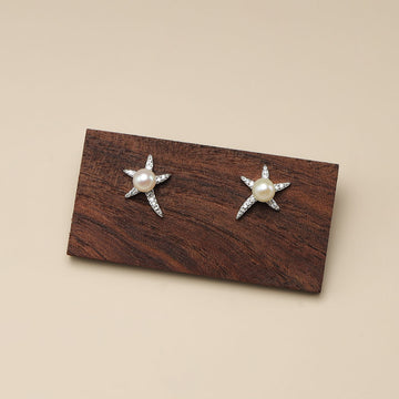 A pair of starfish pearl earrings.