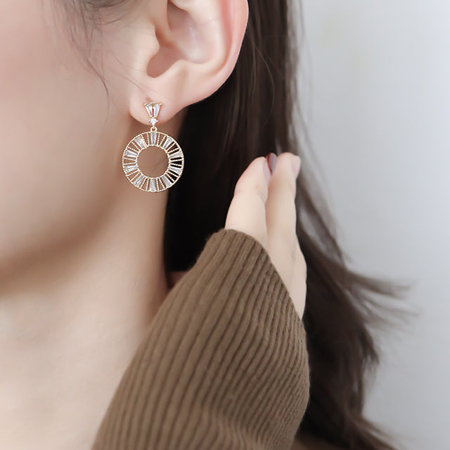 White zirconia earrings on women ear.